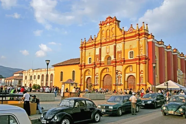 12 Apr 2005, San Cristobal de las Casas, Chiapas, Mexico --- People congregate in late afternoon in front of the Cathedral of San Cristobal de las Casas, in Chiapas, Mexico. The richly textured baroque facade of the Cathedral was recently restored to its original colors of golden-yellow, with red-orange, and white trim. The present structure dates mostly from the 1700's. Following the surprise Zapatista revolt in January 1994, dramatic public negotiations between the Mayan rebels and top Mexican officials were held here. --- Image by © Thom Lang/Corbis
