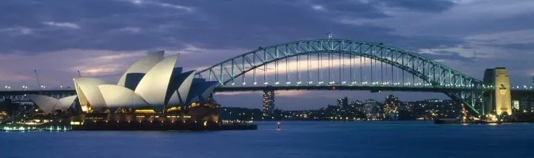 australia, new south wales, sydney, the opera house and harbour bridge lit up at dusk.