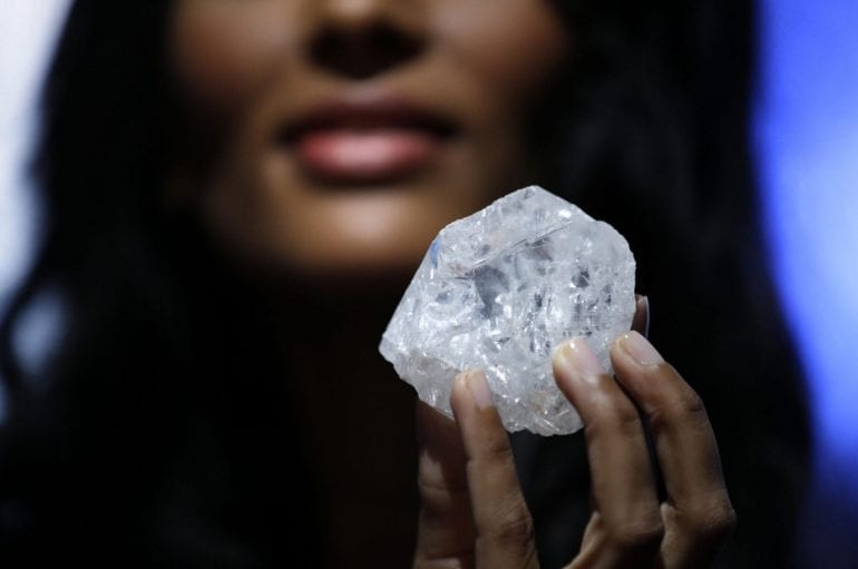 A model displays a large diamond at Sotheby's in New York, Wednesday, May 4, 2016. The diamond the size of a tennis ball  the largest discovered in over a century  could sell for more than $70 million, auctioneer Sotheby's said. (AP Photo/Seth Wenig) ORG XMIT: NYSW105